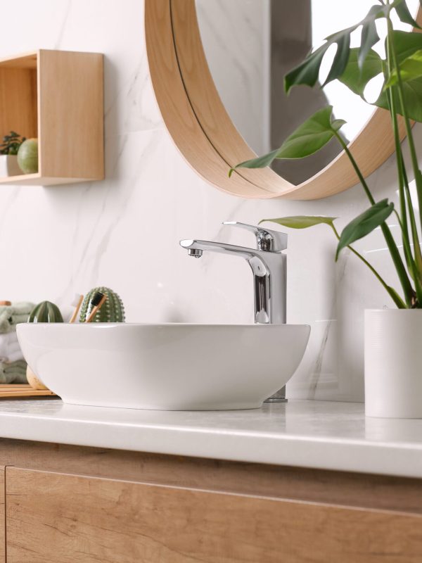 Stylish vessel sink on light countertop in modern bathroom